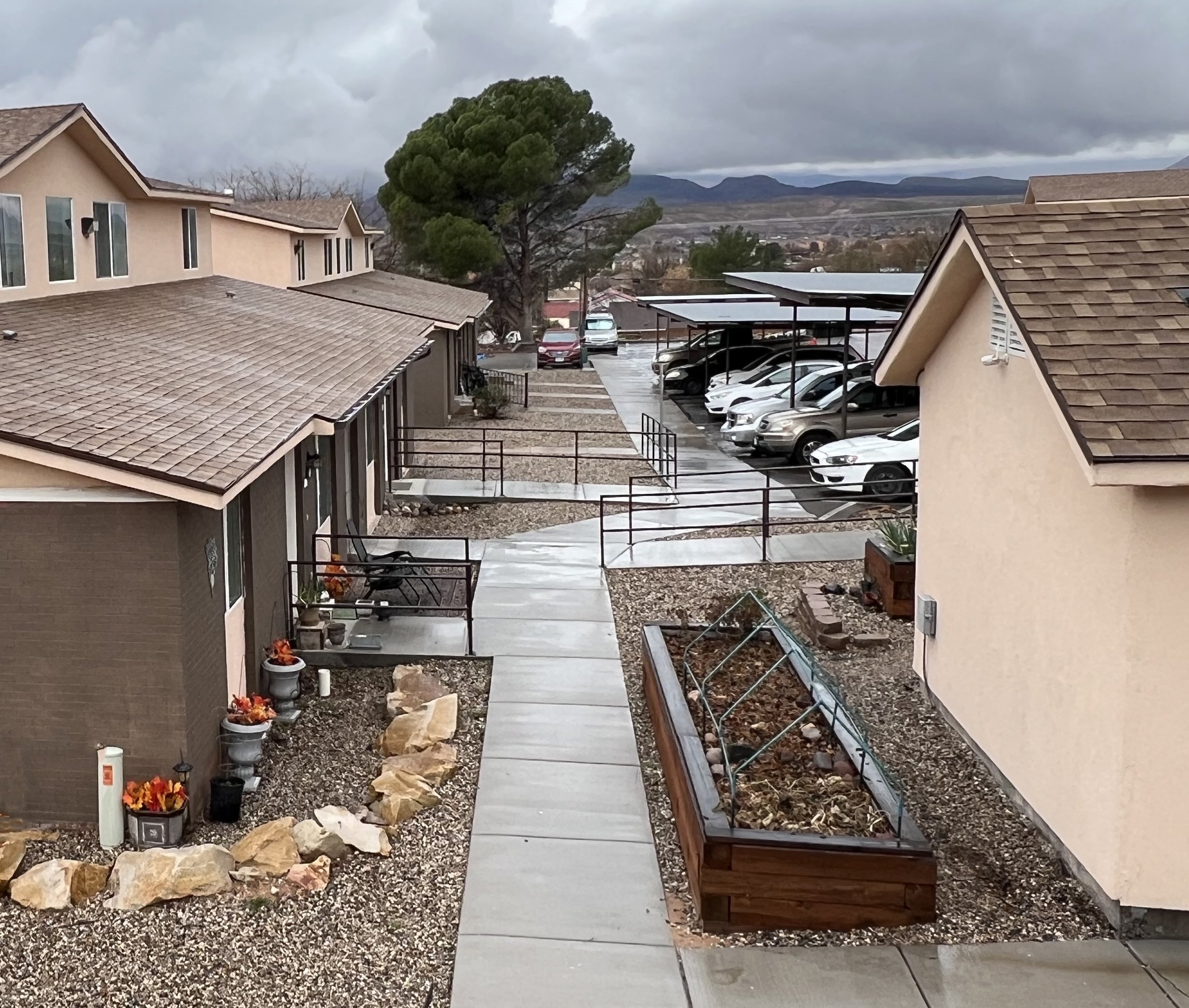 view of property showing units and raised garden beds